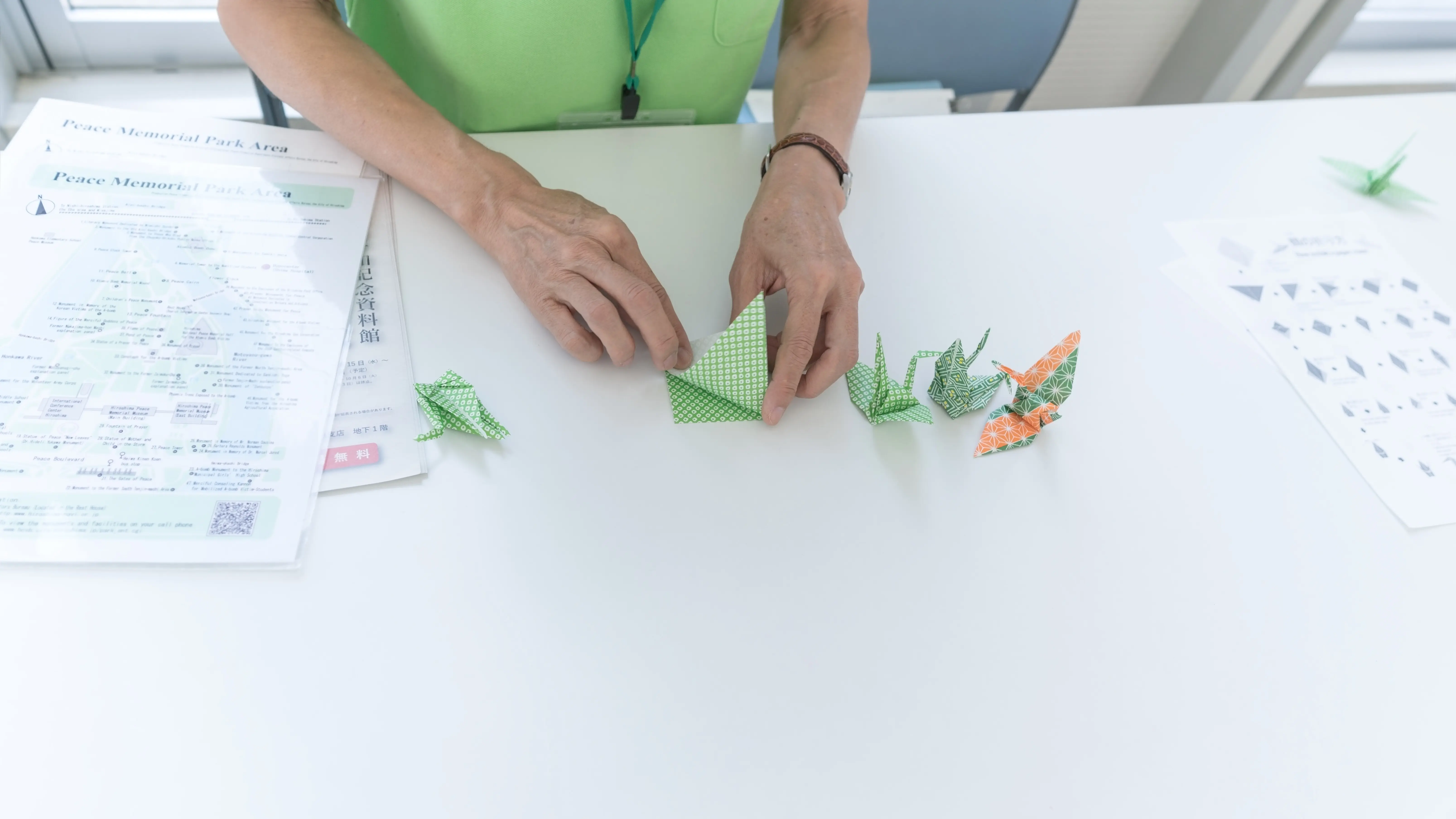 In Hiroshima, Japan, demonstriert eine Japanerin, wie man Origami-Kraniche faltet.